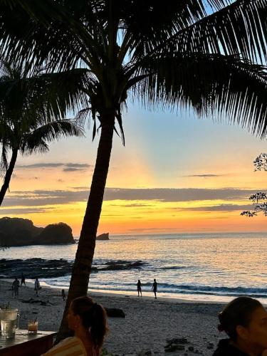 a group of people on the beach at sunset at Casa Vitality Bed and Breakfast - Playa Guiones, Nosara - 4 Minute Walk to the Beach in Nosara