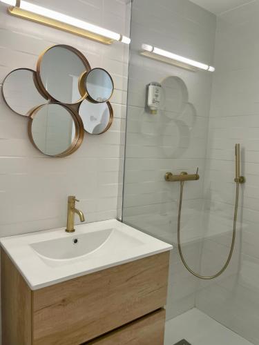 a bathroom with a sink and mirrors on the wall at Hôtel Restaurant La Caravelle in Sari Solenzara