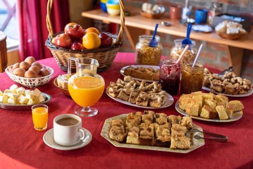 a table topped with plates of food and drinks at La Tosca Hostel in Puerto Madryn