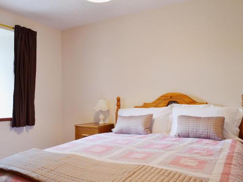 um quarto com uma cama grande e uma janela em Ross Cottage em Cairneyhill