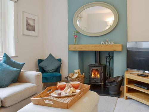 a living room with a fireplace and a mirror at Rectory Cottage in Blankney