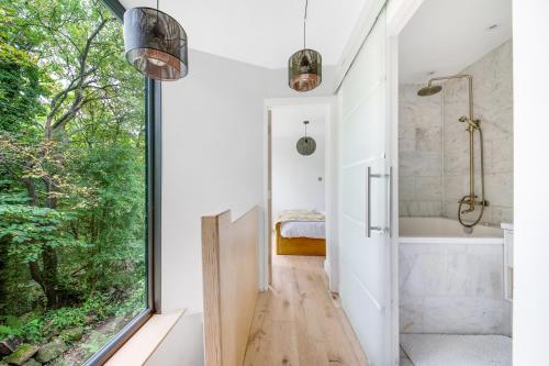 a bathroom with a tub and a shower and a window at The Keep at Castlegate - Luxury detached retreat in Cragg vale, Hebden Bridge in Mytholmroyd