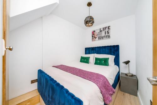 a bedroom with a bed with a blue headboard at The Keep at Castlegate - Luxury detached retreat in Cragg vale, Hebden Bridge in Mytholmroyd