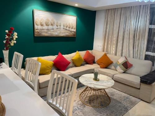 a living room with a couch with colorful pillows at Appartement Anfa Park casa finance City CFC in Casablanca
