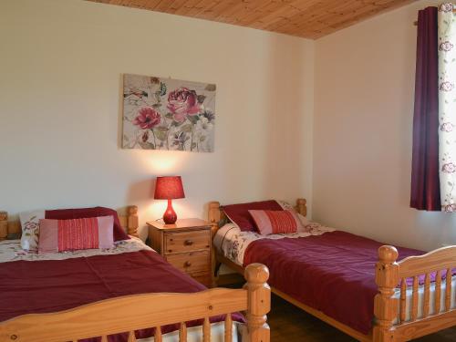 una camera con 2 letti e una lampada su un comodino di Brook View - Hw7477 a Penybont