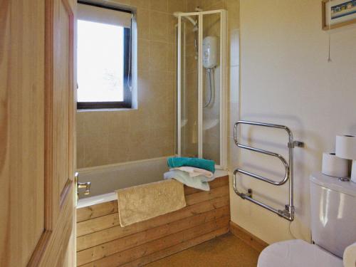 a bathroom with a shower and a tub and a toilet at Brook View - Hw7477 in Penybont