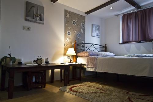 a bedroom with two beds and a table and a desk at Rooms Madison in Zagreb