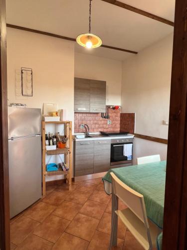 uma pequena cozinha com uma mesa e um frigorífico em Attico Teatro Greco em Catânia