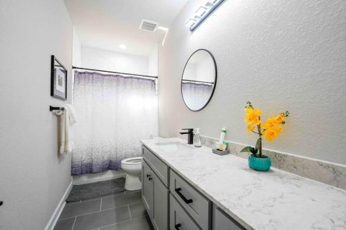 Un baño con lavabo, inodoro y espejo. en Casa Lavaca Luxury, en San Antonio
