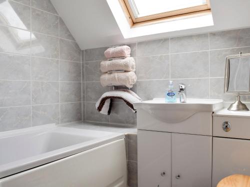 een badkamer met een wit bad, een wastafel en een bad tubermott bij The Ploughmans - Uk5531 in Kepculloch