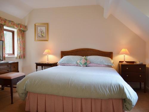 Pear Tree Cottage في Kinlet: غرفة نوم بسرير كبير مع مواقف ليلتين