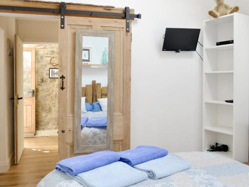 a bedroom with a door with a mirror and a bed at The Figgery in Wrangaton