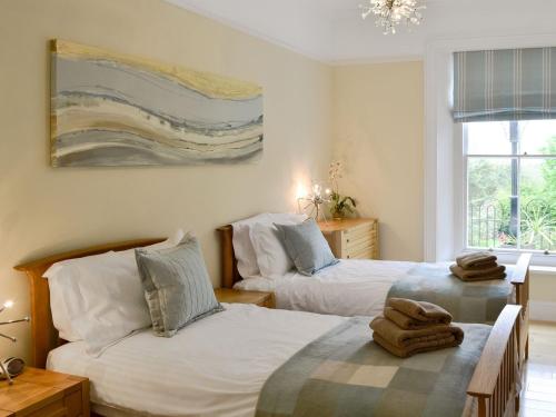 a bedroom with two beds with towels on them at Carnethic House - One Acre View in Fowey