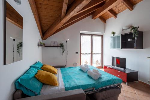 a bedroom with a large bed with a couch at [10' from Malpensa] Shuttle, Netflix & Wi-Fi in Casorate Sempione