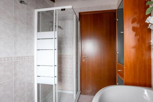 a shower with a glass door in a bathroom at [10' from Malpensa] Shuttle, Netflix & Wi-Fi in Casorate Sempione