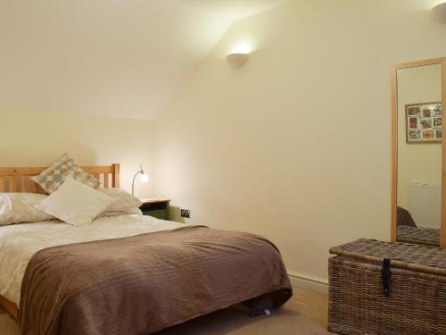a bedroom with a bed and a mirror at Valeview Cottage in Great Malvern