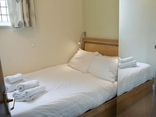 a bedroom with a bed with towels on it at Howegrain Lodge in Glenridding