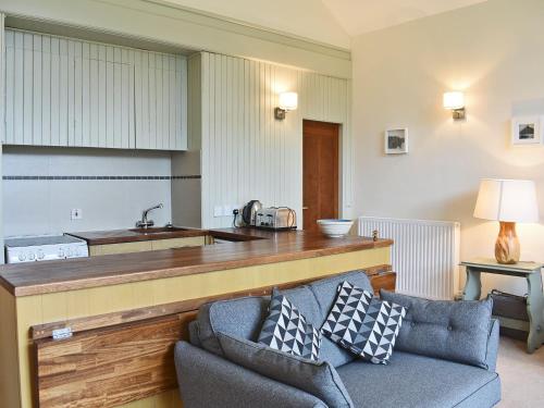 un soggiorno con divano e una cucina di Howegrain Lodge a Glenridding