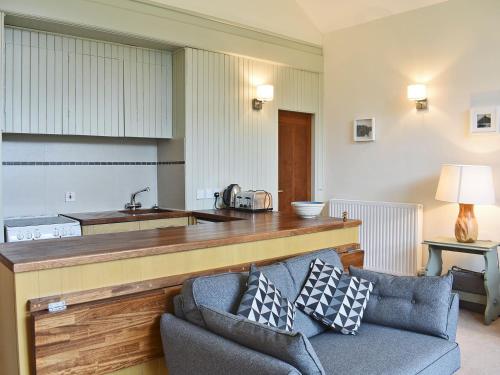 a living room with a couch and a kitchen at Howegrain Lodge in Glenridding
