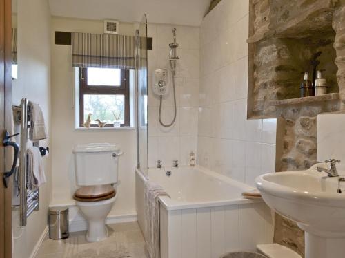 ein Badezimmer mit einem Waschbecken, einem WC und einer Badewanne in der Unterkunft Curlew Barn in Middleham