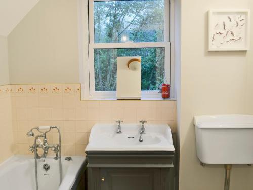 a bathroom with a sink and a tub and a window at Tower Cottage - Mvw in Belsay