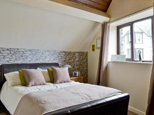 a bedroom with a large bed with a brick wall at The Round Window in Bowness-on-Windermere