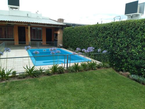 una piscina en un patio junto a un seto en Cabañas Olivos y Bodegas en San Rafael