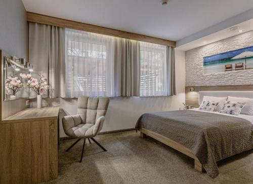 um quarto com uma cama, uma secretária e uma cadeira em Apartamenty Czarny Kormoran em Hel