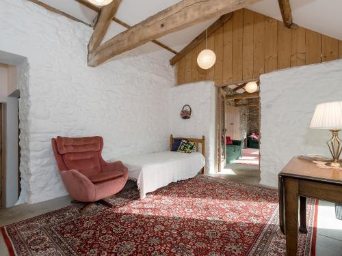 a bedroom with a bed and a chair and a table at Cowdber Barn in Cowan Bridge
