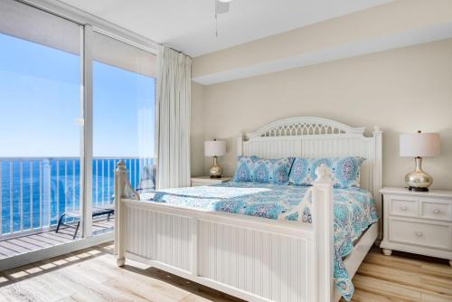 Biała sypialnia z łóżkiem i balkonem w obiekcie Tidewater 2115 w mieście Panama City Beach