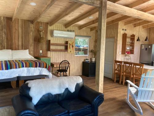 a bedroom with a bed and a couch in a room at Cabañas Almalik in Ralún