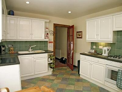 a kitchen with white cabinets and a sink and a counter at 5 Milnamair in Montrose