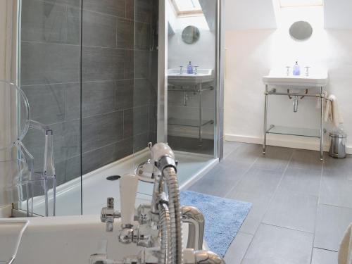 uma casa de banho com um chuveiro, um lavatório e uma banheira em Granny Mcphees Cottage Hssh em Beaworthy