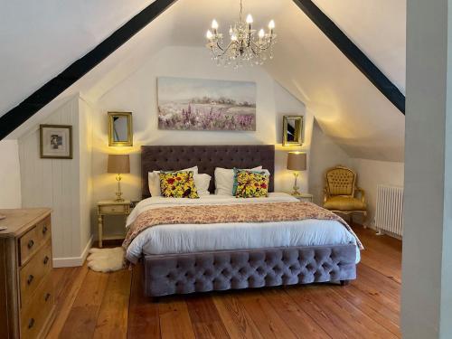um quarto com uma cama e um lustre em Granny Mcphees Cottage Hssh em Beaworthy