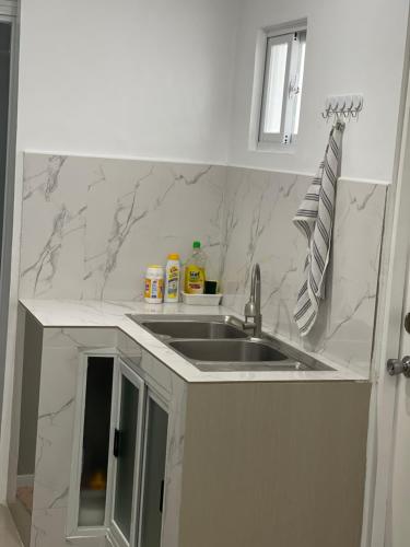 a kitchen with a sink and marble counter top at Modern Cozy 3BR Near Air-conditioned & Free Parking in Silang