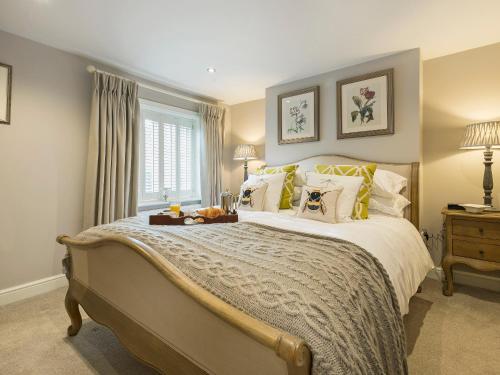 a bedroom with a large bed with yellow pillows at Pear Tree Cottage in Louth