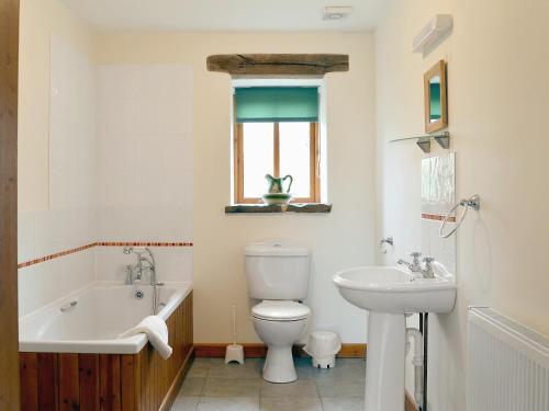a bathroom with a tub and a toilet and a sink at Chive - E4326 in Ludham