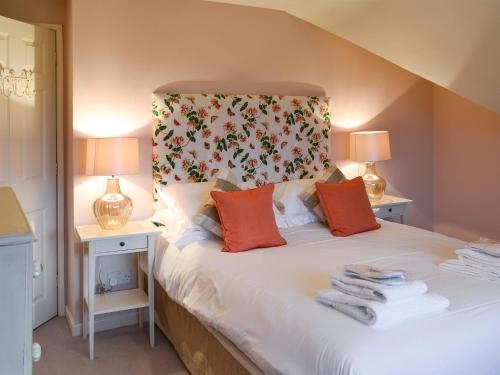 a bedroom with a bed with two night stands and two lamps at Foulden Hill Farm Cottage in Foulden
