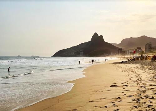 un grupo de personas caminando por la playa en Stay in Leblon - Beach paradise 3-bedroom for families and groups, en Río de Janeiro