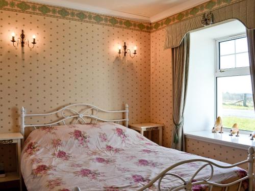 1 dormitorio con cama y ventana en Belloch Cottage, en Glenbarr