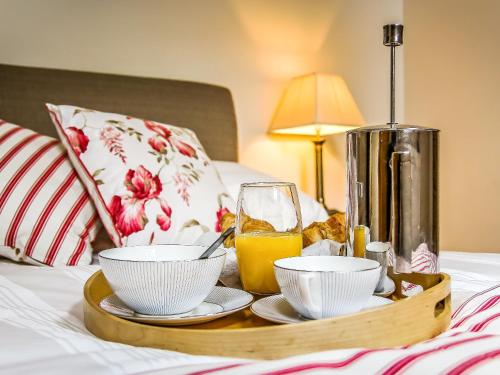 a tray with food and a glass of orange juice on a bed at The Farmhouse At Gradbach in Flash