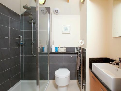 een badkamer met een douche, een toilet en een wastafel bij Tullibole Castle Longhouse in Crook of Devon