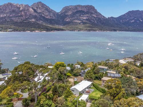 an aerial view of a town and the water with mountains at Fish @ Freycinet in Coles Bay