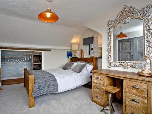 a bedroom with a bed and a large mirror at Fishlegs in Brixham