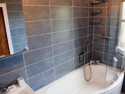 a bathroom with a shower and a bath tub at St Andrews Hideaway in St. Andrews