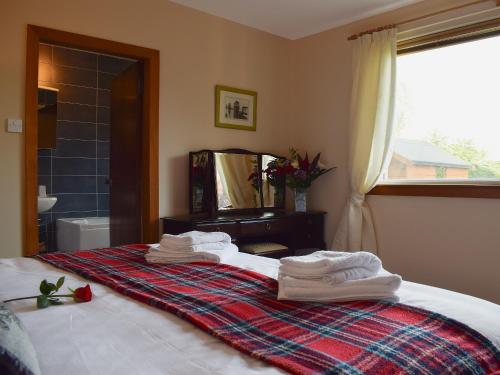 a bedroom with a bed with towels on it at St Andrews Hideaway in St. Andrews