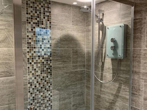 a bathroom with a shower with a glass door at Rock Cottage in Crosthwaite