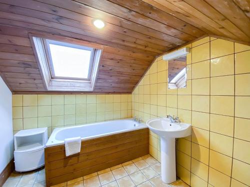a bathroom with a bath tub and a sink at Sweet Coppin in Ledbury