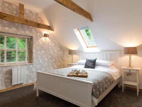 AislabyにあるThe Pamper Lodgeのベッドルーム1室(屋根裏に大きな白いベッド1台付)