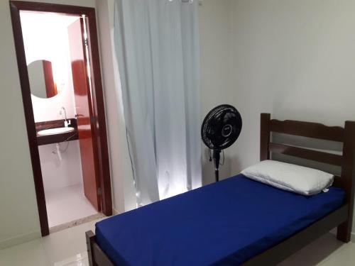 - une chambre avec un lit bleu et un ventilateur dans l'établissement Casa em Costazul - Rio das Ostras, à Rio das Ostras